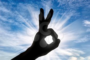 Success concept. Silhouette of man's hand shows the gesture OK