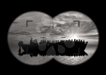 Refugees concept. View from the binoculars on a boat with refugees at sea