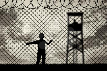 Refugee children concept. Child refugee, near the fence of barbed wire and guard towers