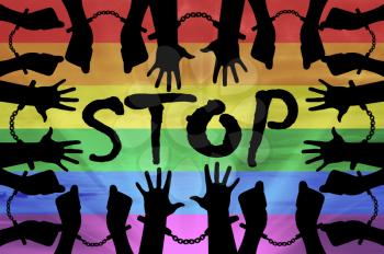 Stop discrimination against gays concept. Silhouette gay hands in handcuffs on the background of the rainbow