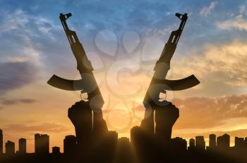 Terrorist concept. Weapons in the hands of terrorist, against the background of the city