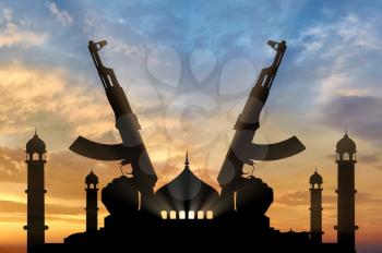 Terrorist concept. Weapons in the hands of terrorist, against the background of the mosque