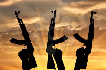 Terrorists concept. Weapons in the hands of terrorists, on the sunset background
