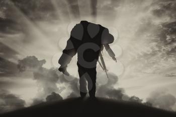 War and conflict concept. Soldier carries a wounded soldier on a background of the sky in smoke