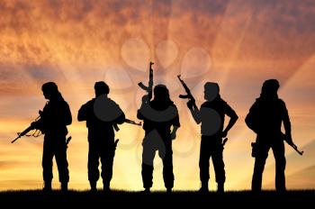 Terrorism and conflict. Armed terrorists at sunset