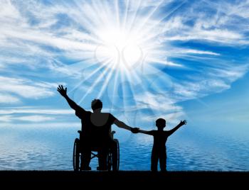 Happy disabled person in wheelchair hold son for hand and they happy near sea day. Concept happy disabled and family
