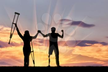 Disabled people with prosthesis and crutches to hold hands on sunset background. Concept disabled