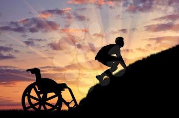 Concept of disability and self-motivated. Silhouette of disabled person to climb the hill at sunset