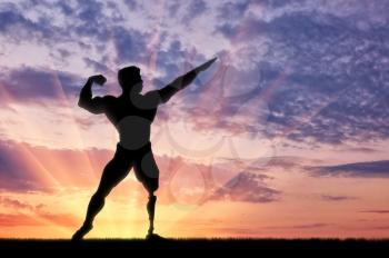 Disabled bodybuilder with prosthesis on leg is in pose on sunset. Concept handicapped and sport