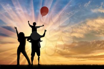 Happy disabled with prosthetic legs walking with his wife and child with balloon sunset. Concept happy disabled