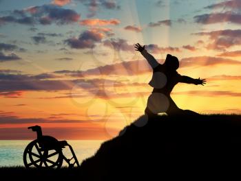 Concept of disability and positive. Silhouette of disabled person to experience happiness on a hilltop at sunset