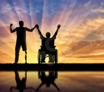 Disabled person with prosthetic leg and disabled in wheelchair holding hands and reflection in water on sunset. Concept disabled