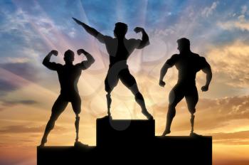 Invalids bodybuilders stand on pedestal and rewarding on sunset background. Concept handicapped and sport
