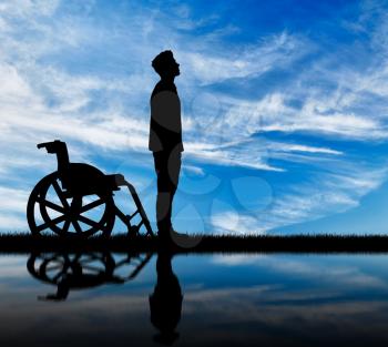 Concept of disability and disease. Silhouette of disabled and wheelchair daytime and reflection in water