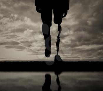 Leg prosthesis and reflection in water black and white. Concept disabled