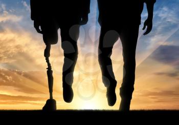 Leg man with prosthesis and normal legs on background sunset. Concept disabled person