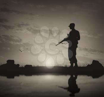 Concept of terrorism and war. Silhouette of a terrorist with a weapon  and reflection