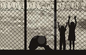 Concept of refugee. Silhouette of a refugee family, a mother in despair with children on the background of the border