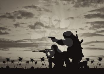 Concept of terrorism. Silhouette of a terrorists with a rifle on a background of sunset and palm trees