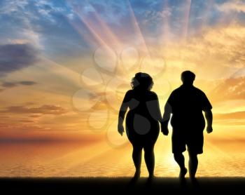 Couple with overweight standing near sea sunset. Overweight concept