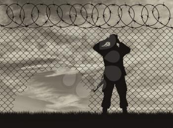 Concept of the refugees. Silhouette border guards near the hole in the fence