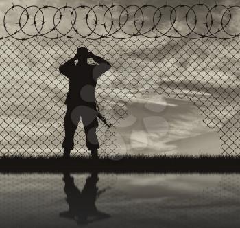Concept of the refugees. Silhouette border guards near the hole in the fence and reflection