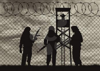 Concept of terrorism. Silhouette terrorists near the border fence in the background at sunset
