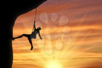 Alpinist climbs on cliff sunset. Concept mountaineering