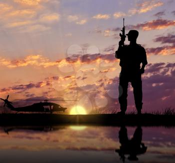 Concept of terrorism and war. Silhouette of a terrorist with a weapon against a background of military helicopters and reflection