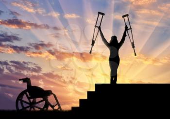 Happy disabled person standing on stairs and holding crutches wheelchair. Concept happy disabled