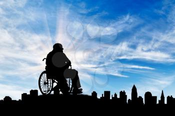 Concept of disability and old age. Silhouette of disabled person on a background of cityscape day