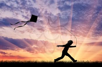 Happy child running with kite on sunset. Happiness concept