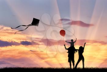 Young family with child flying kite sunset walk and child with balloon. Concept family