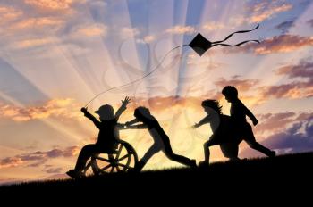 Happy boy in wheelchair playing with children and kite sunset. Concept happy child disabled