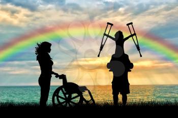 Happy disabled child on the father shoulders holding crutches nurse and wheelchair rainbow sea. Concept child disabled