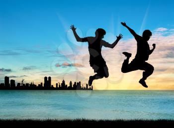 Concept of gay people. Silhouette of two happy gays jump on the background of sea sunset and city