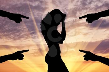 Concept of deceit and betrayal. Silhouette of a woman and condemning the hands of people at sunset