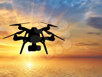 Silhouette of a flying drone on a background of sea sunset