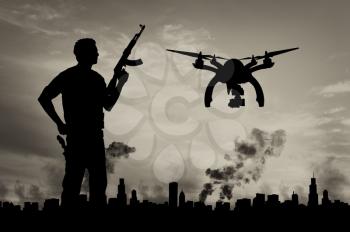 Silhouette flying reconnaissance drone over city in a smoke and a terrorist. Concept of military intelligence and terrorist information