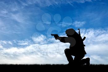 Concept of terrorism. Silhouette of a terrorist with a gun against the sky