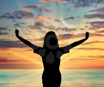 Concept of emotions and feelings. Silhouette of a happy woman on a background of sea sunset