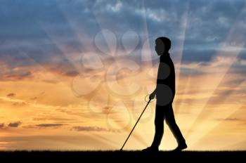 Blind man with cane disabled person goes on street sunset. Concept help blind people disabilities