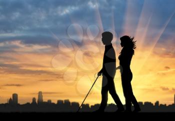 Blind man with cane disabled and nurse are on background of city and sunset. Concept help blind disabilities