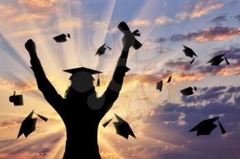 Graduate raised his hands to sky and holds diploma graduate cap and sunset. concept of education