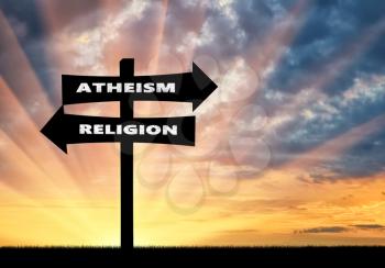 Belief concept. Road sign atheism and religion at sunset