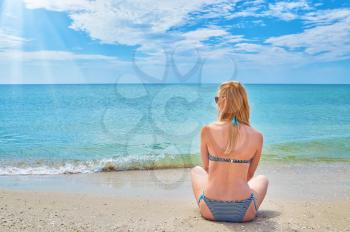 Young woman resting at the sea sitting on the sand. tourism and recreation concept