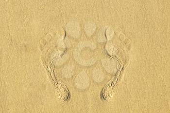 Human footprints on the sand at the beach. The concept of a beach holiday
