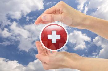 Concept of medicine and the Red Cross. red cross symbol in human hands against the sky