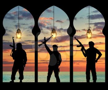 Silhouette of three terrorists with a weapon against a background of sea sunset in the building