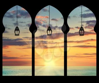 Silhouette arches inside the building of the mosque and the lights on the background of sea sunset